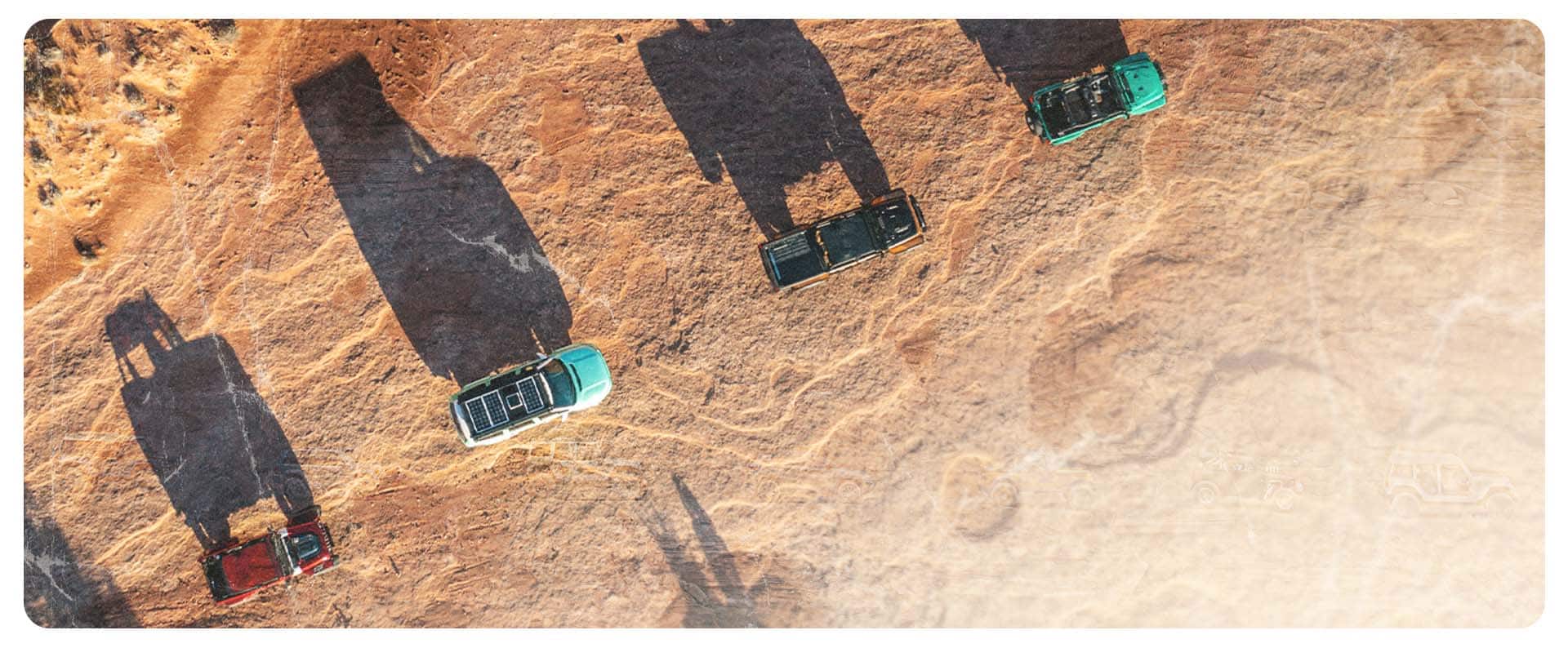 A high overhead angle of four Jeep Brand concept vehicles traveling one after another on a mountain trail in Moab, Utah.